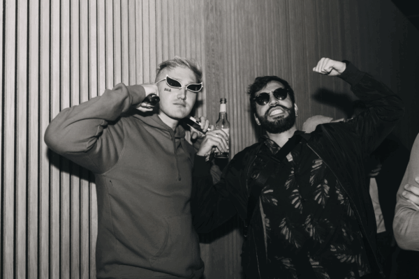 unge Kollegen lachen und stoßen an auf Firmenevent – moderne Arbeitgeberkultur mit Spaß, Teamspirit und motivierender Atmosphäre.